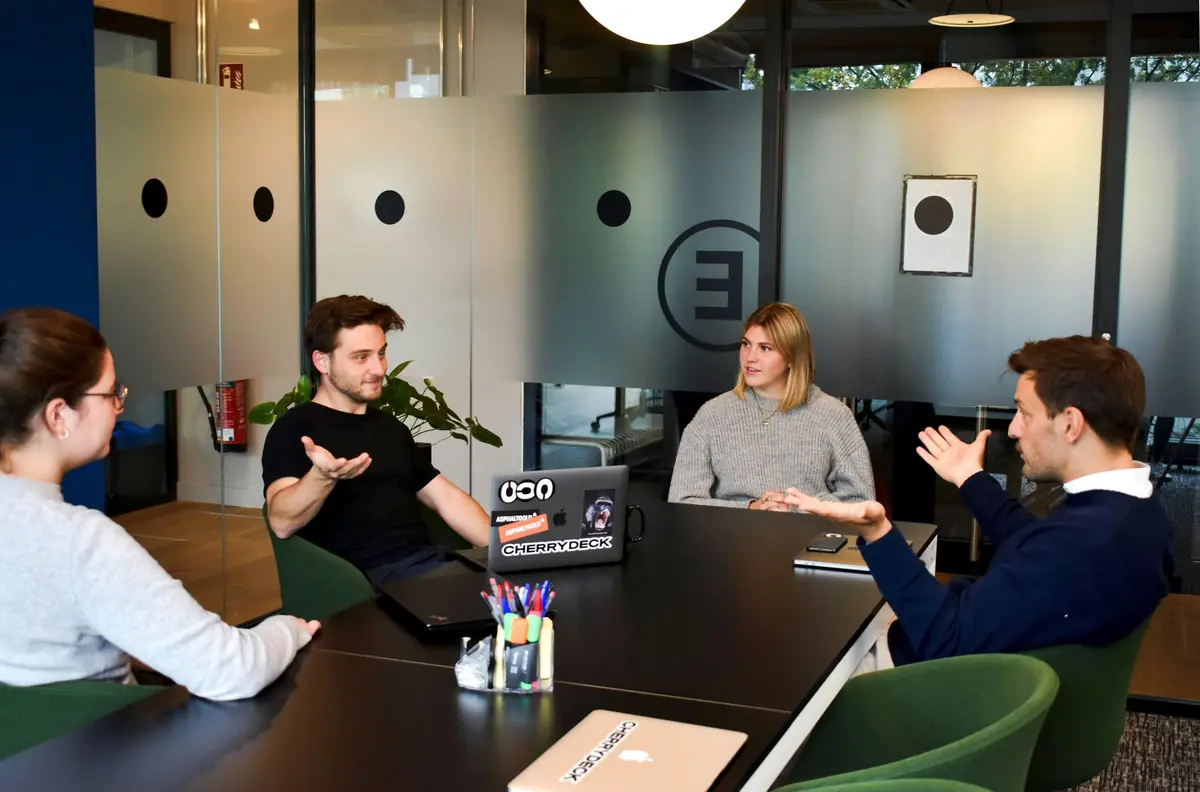 Four people in a meeting around a table.